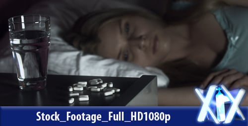 Woman Sleeping in Bed Next to Pills at Night