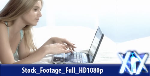 Blonde Woman Lying on Bed Typing on Laptop