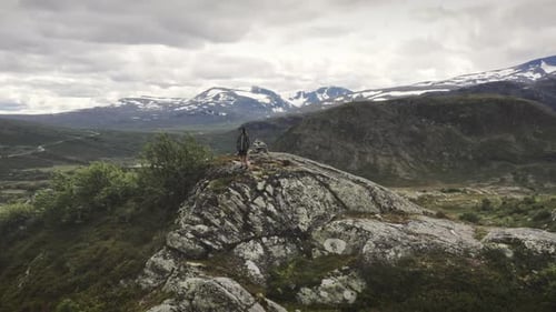 Drone Of Boy Standing On Cliff In Landscape