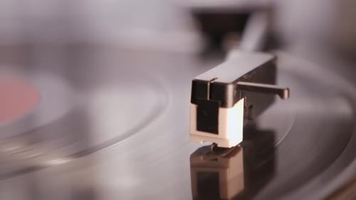 Record Player Needle Playing a Spinning Vinyl Record