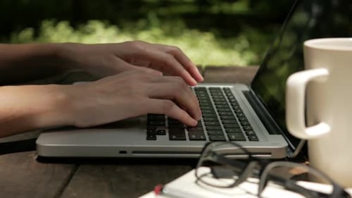 Typing on Laptop Computer Outdoors