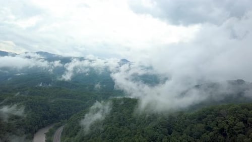 4K-Drohne steigt durch Wolken und Berge