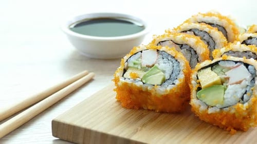Fresh Sushi Rolls with Roe on Wood Board