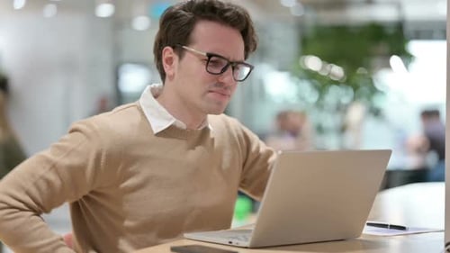 Man with Laptop Having Back Pain in Office