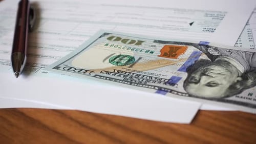 Tax Form and Money on a Wood Table