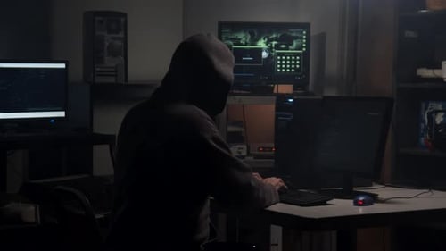 Hooded Hacker Typing Code at Multiple Computers