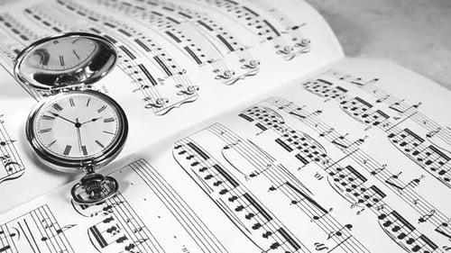 Vintage Pocket Watch on Open Sheet Music Book