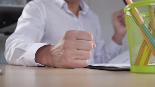 Angry Adult at Desk Hits it with Fist