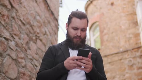 Man Uses Mobile Phone in Urban Environment