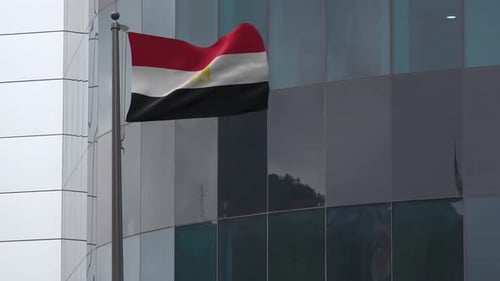 Egyptian Flag Waving on a Pole by Modern Building