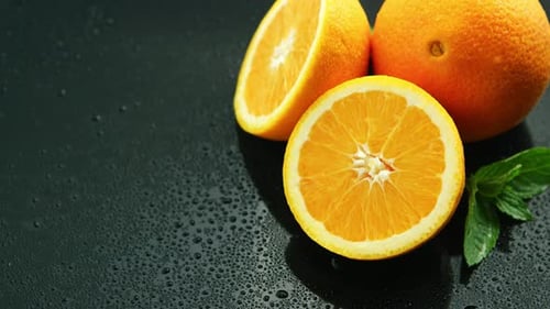 Naranja con hoja sobre mesa mojada