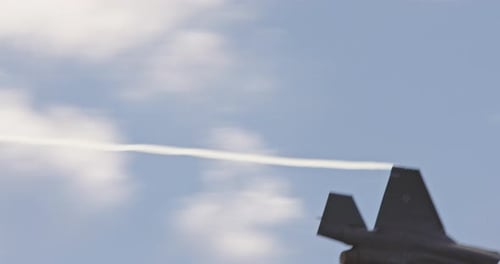 Majestic Fighter Jet Soaring in Sky Emitting Smoke