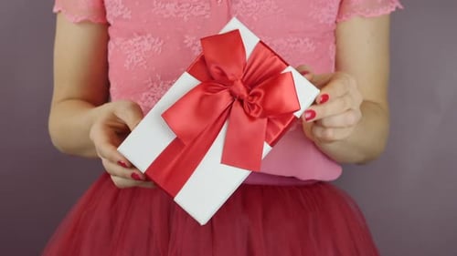 Close up of Woman Holding Gift with Red Bow