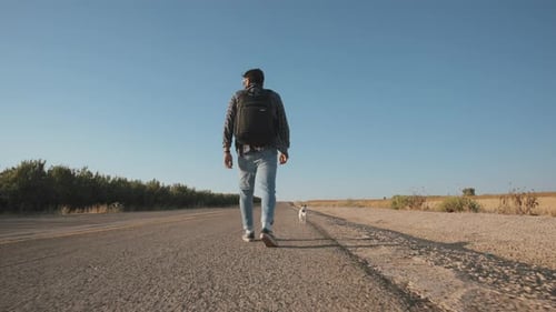 Man walks on the side of a road