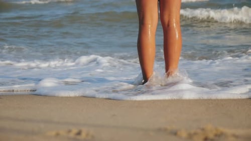 Female Legs Washed By the Waves of the Sea, Close-up
