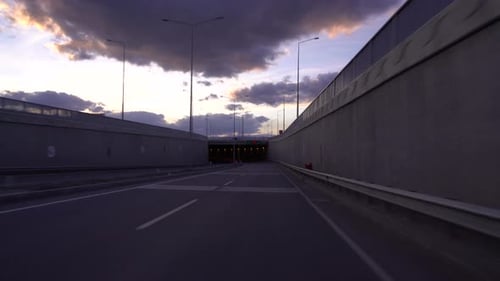 Driving Into Tunnel at Sunset Under Stormy Sky