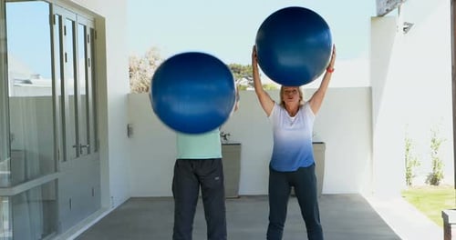 Senior couple exercising with exercise ball