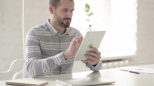 Man at Desk Using Tablet Device