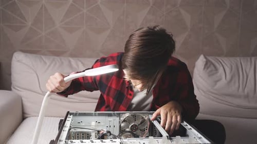 Young Man Repairs a Desktop Computer