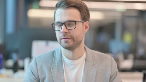 Man with Glasses Looks at Camera