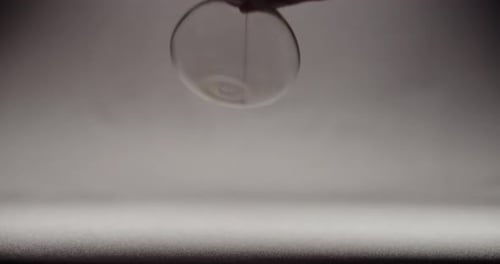 A hand rotating an hourglass