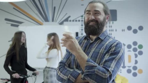 Man Drinks Coffee in a Bright Office Space