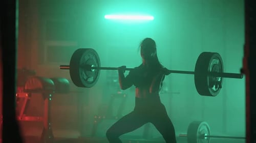 Slow Motion Athletic Beautiful Woman Does Overhead Deadlift with a Barbell in the Gym