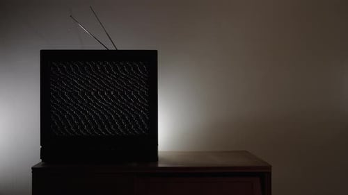 Vintage Television Displaying Static in Dimly Lit Room