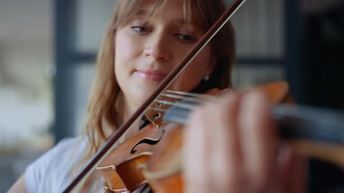 Young Woman Serenely Playing Violin Indoors