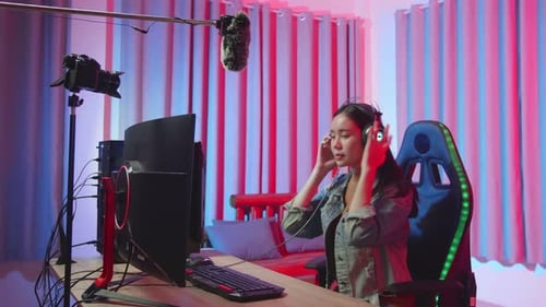 Woman Sits Down and Puts on Headphones to Game