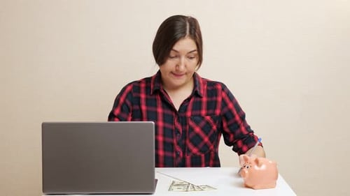 Lady Plans Budget Inserting Dollar Bill Into Piggy Bank