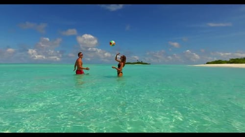 Man and lady posing on idyllic seashore beach lifestyle by transparent ocean with bright sandy backg
