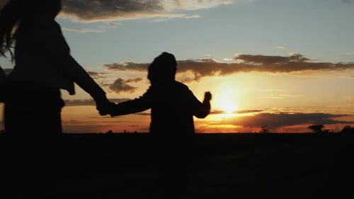 Family Walking Together During Colorful Sunset Silhouette
