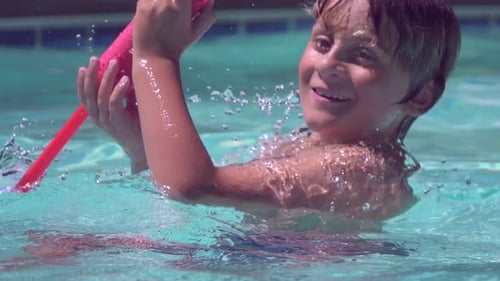 A boy plays in a pool at a hotel resort.