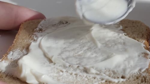 Spreading Creamy White Spread on Whole Wheat Bread
