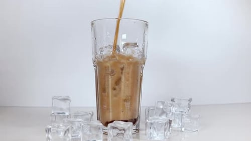 Refreshing Soda Pouring Into Glass with Ice