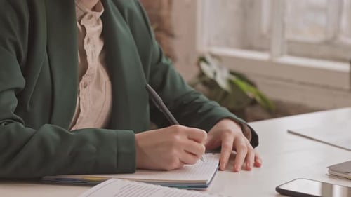 Geschäftsfrau macht sich Notizen am Arbeitsplatz