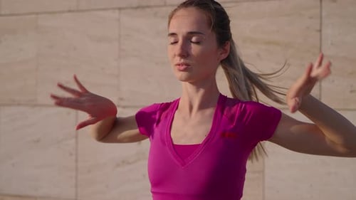 Woman Stretching Arms Outdoors in Pink Top
