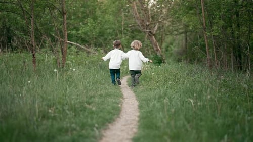 Little Ukrainian Boys Cheerfully Running Along Path on Forest Lawn or in Park