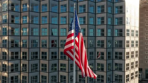 American Flag Waving in Front of Modern Building