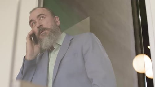 Man Talking on Smartphone in Office Environment