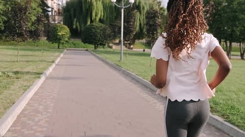 Young Active African American Woman Jogging in Park To Keep Healthy