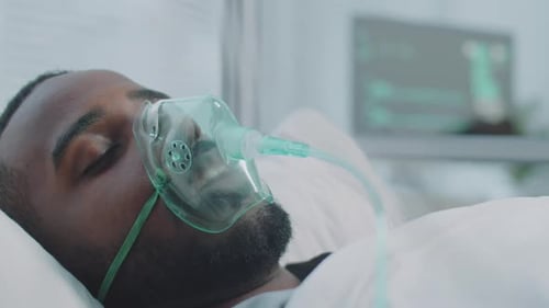Afro-American Man on Ventilator in Hospital Ward