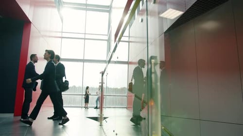 Büroangestellte in formeller Kleidung treffen sich in Lobby beim Händeschütteln