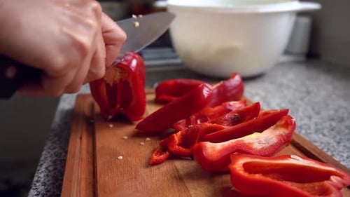 Cutting Fresh Red Bell Pepper On Wooden Chopping Board. close up, slow motion