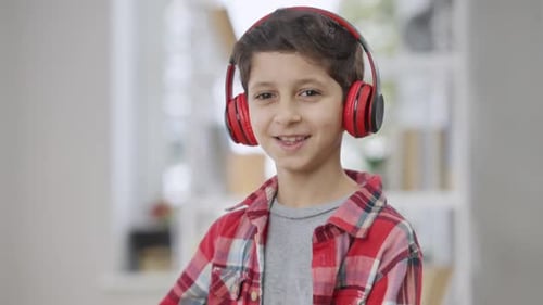 Boy with Headphones Listening to Music Indoors