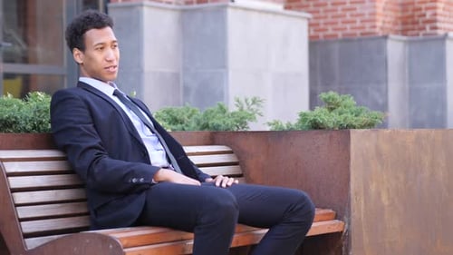 Smiling Man in Business Suit Gives Thumbs Up