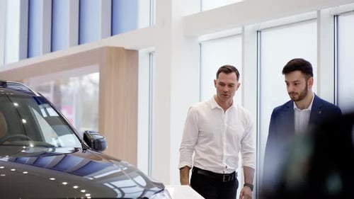 Men Discuss Car Purchase at Dealership