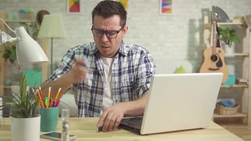 Man Using Inhaler While Using Laptop