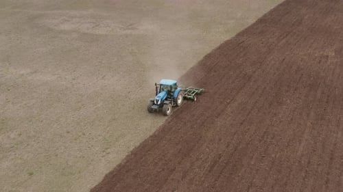 Tractor Tilling Soil in Rural Farm Field